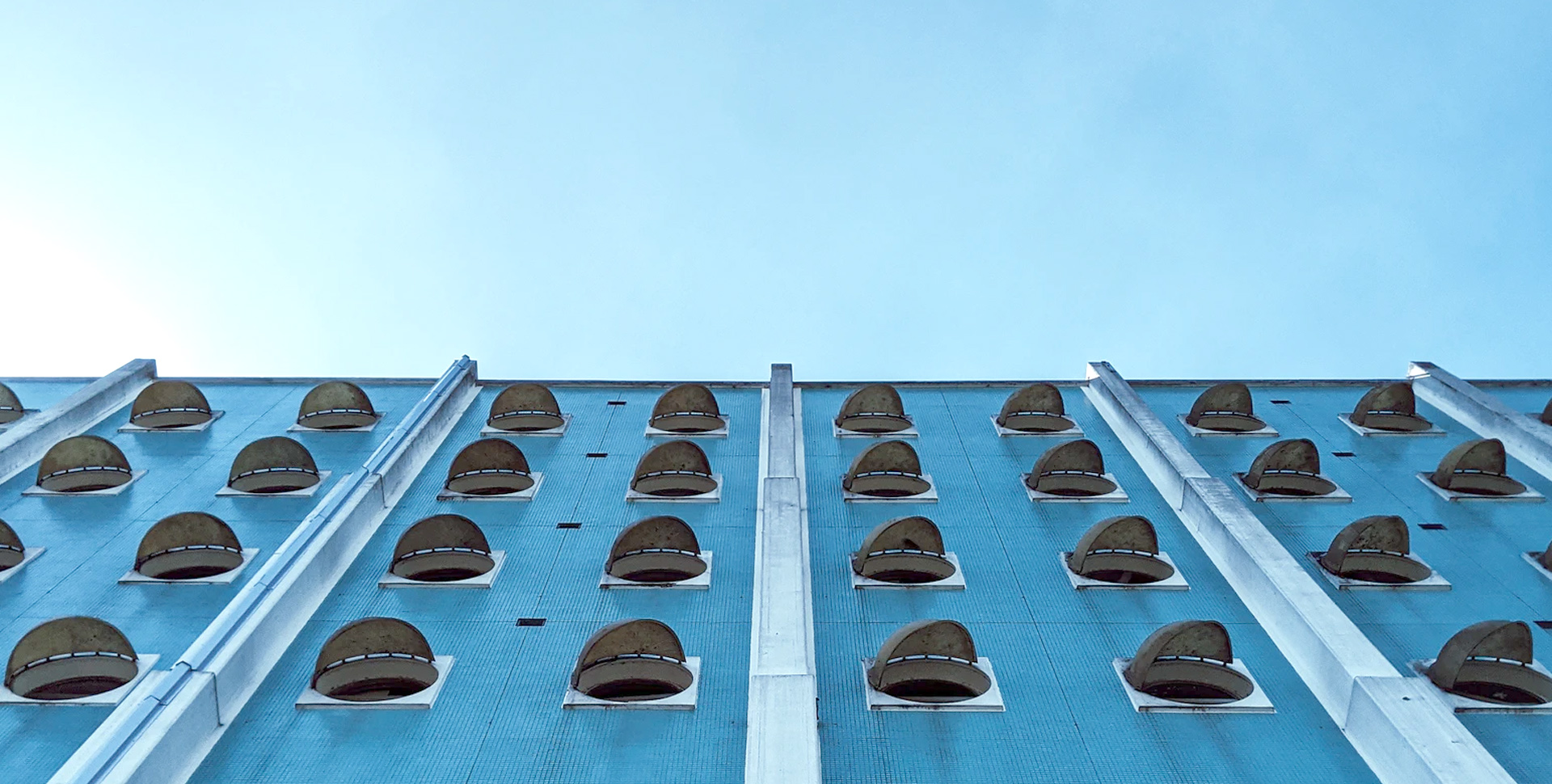 A modern building over a blue sky.