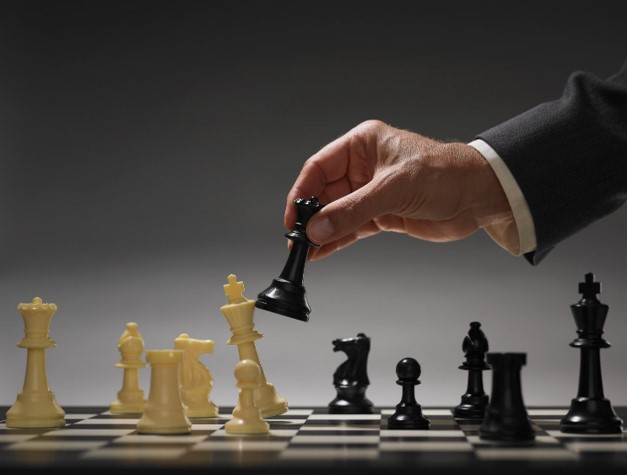 A hand playing the winning move at a chess game.