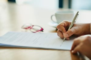 Close up of someone signing a document.