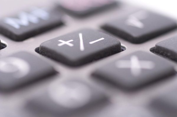 Super close up of a calculator's plus and minus button.